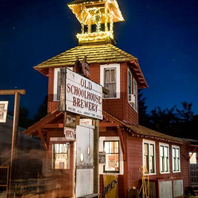 A red building with a sign that says old schoolhouse brewery