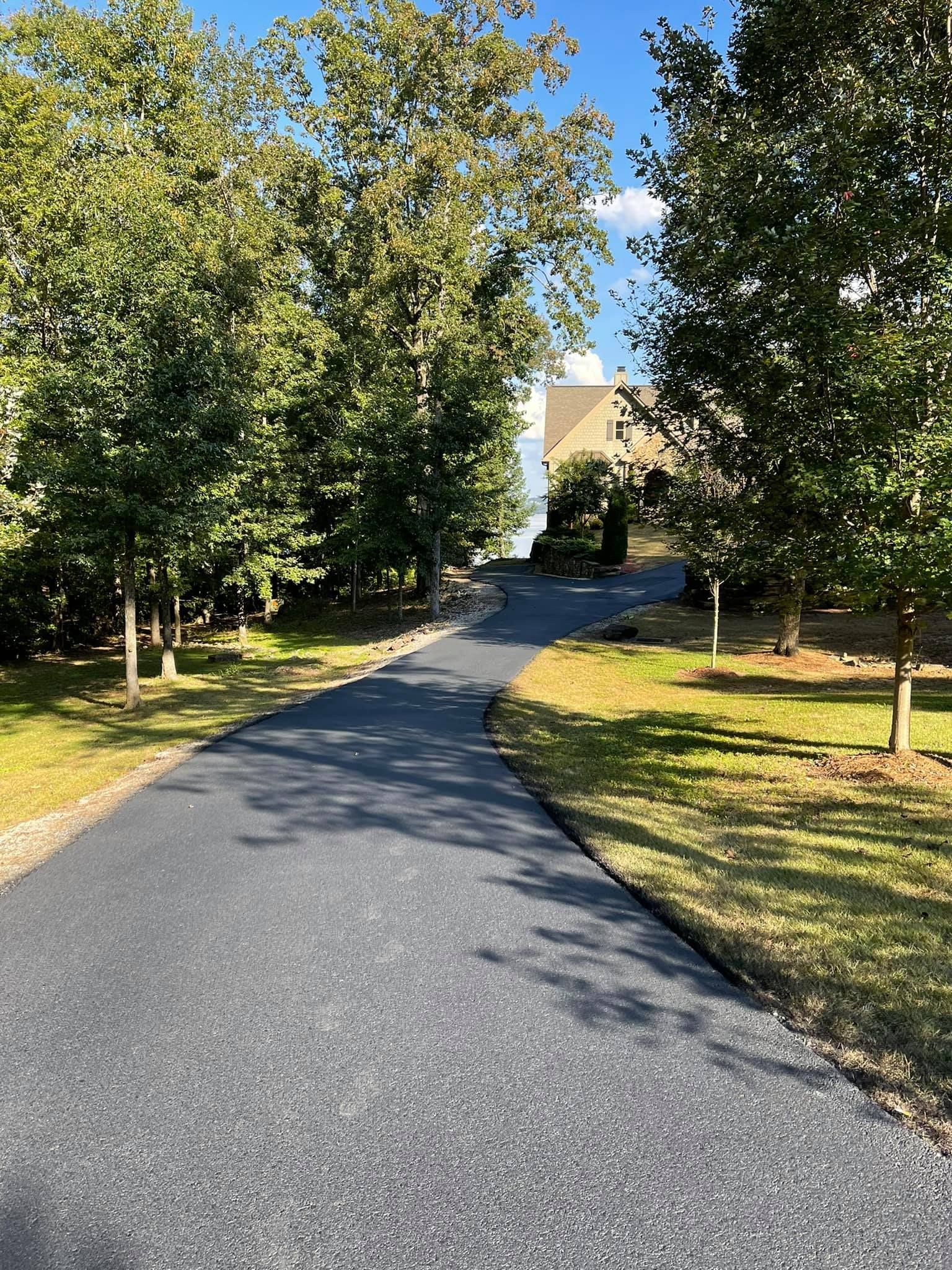 A yellow asphalt paver lays a fresh, black layer of hot pavement along a concrete curb.