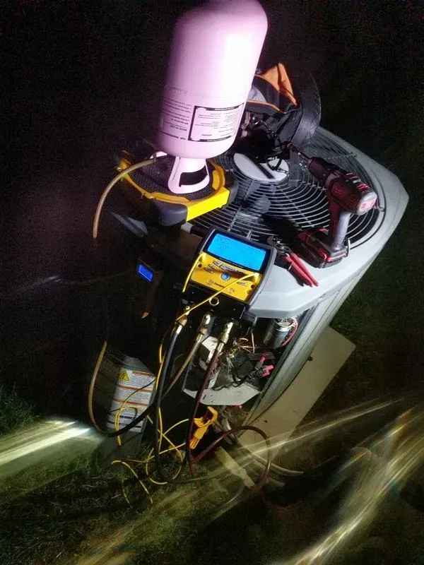 A bunch of tools are sitting on top of an air conditioner.