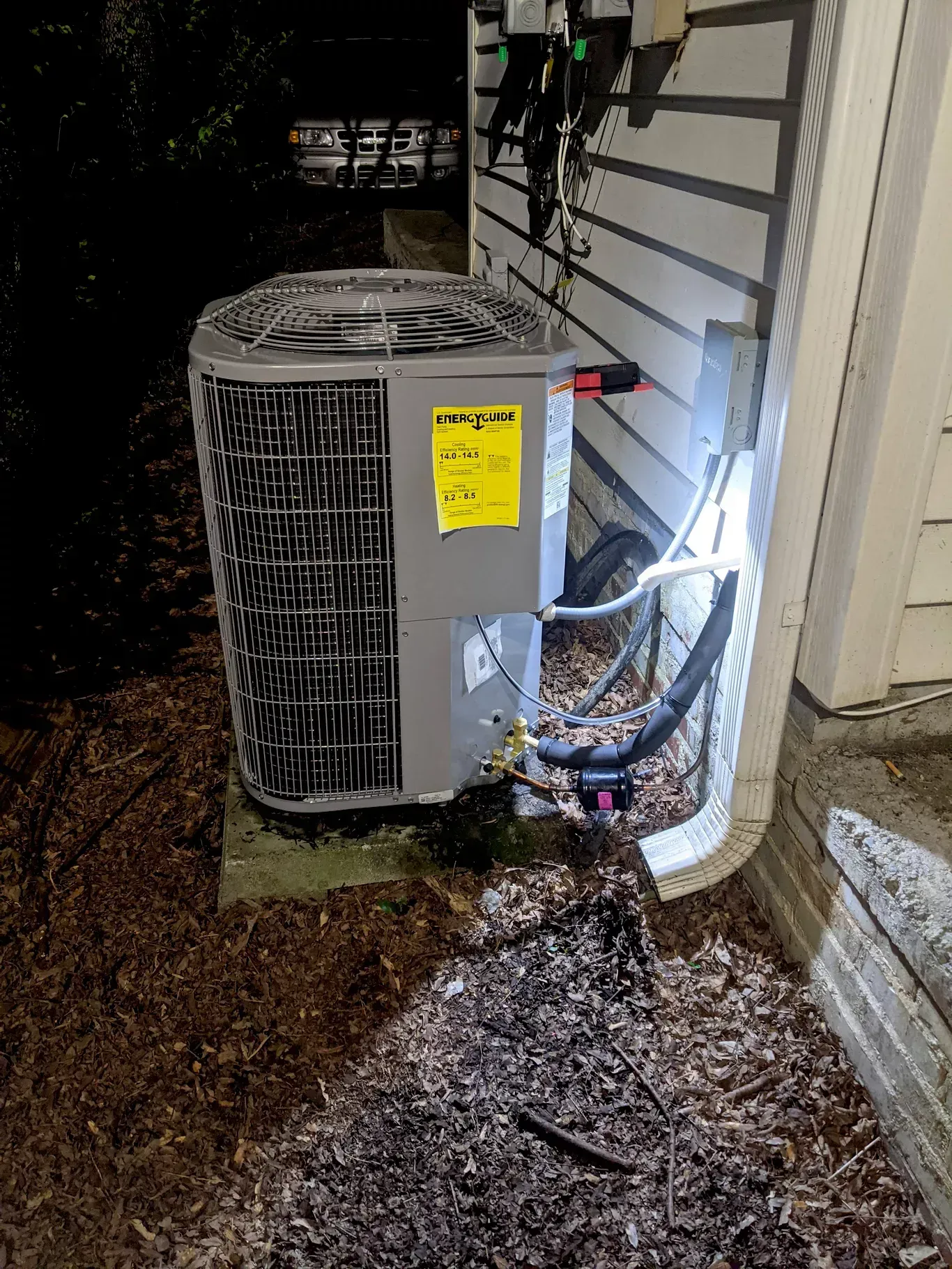 An air conditioner is sitting on the side of a house.