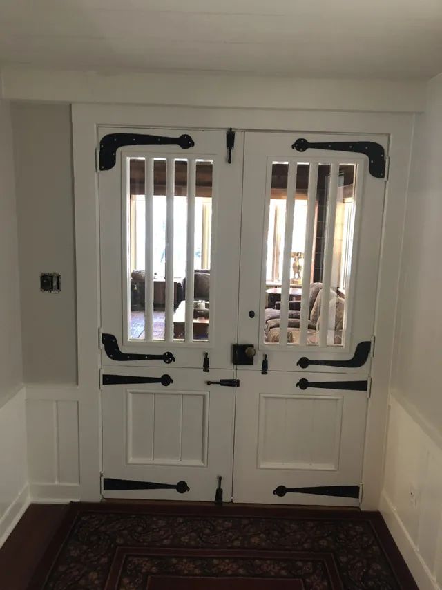 White double doors with black hardware and vertical bars; visible interior.