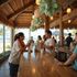 People enjoying ice cream at a beachfront bar. Wooden counter, thatch roof, ocean view.