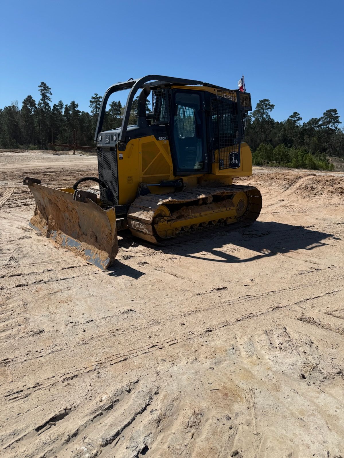 A yellow bulldozer is sitting on top of a dirt field.