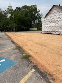 A parking lot with a handicapped parking spot and a building in the background.