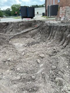 A large pile of dirt and rocks is sitting in front of a building.