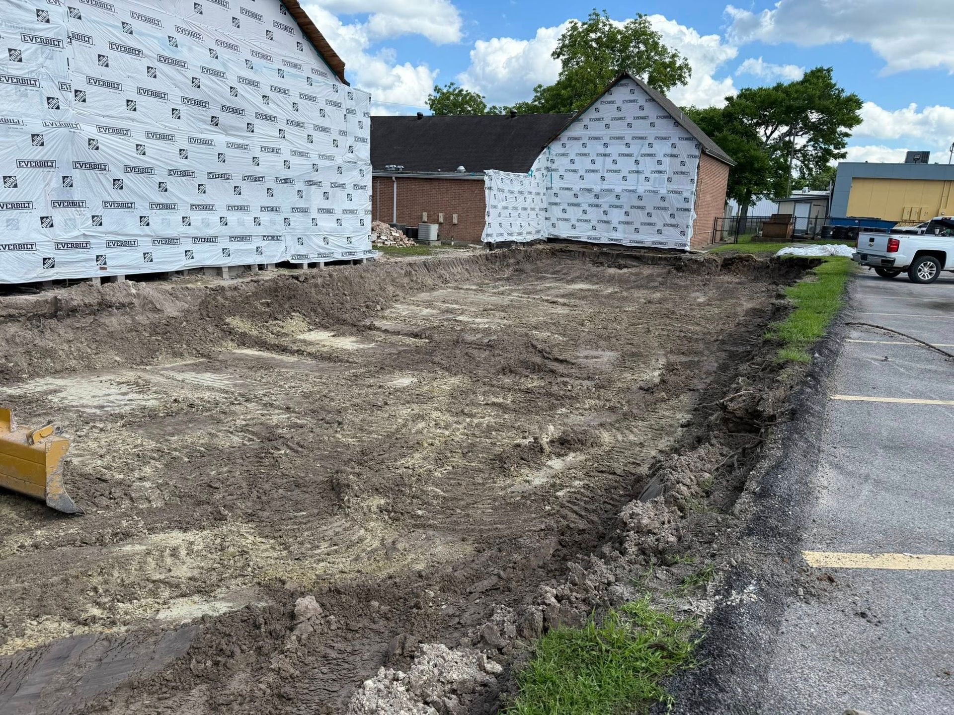 A truck is parked on the side of the road next to a dirt field.