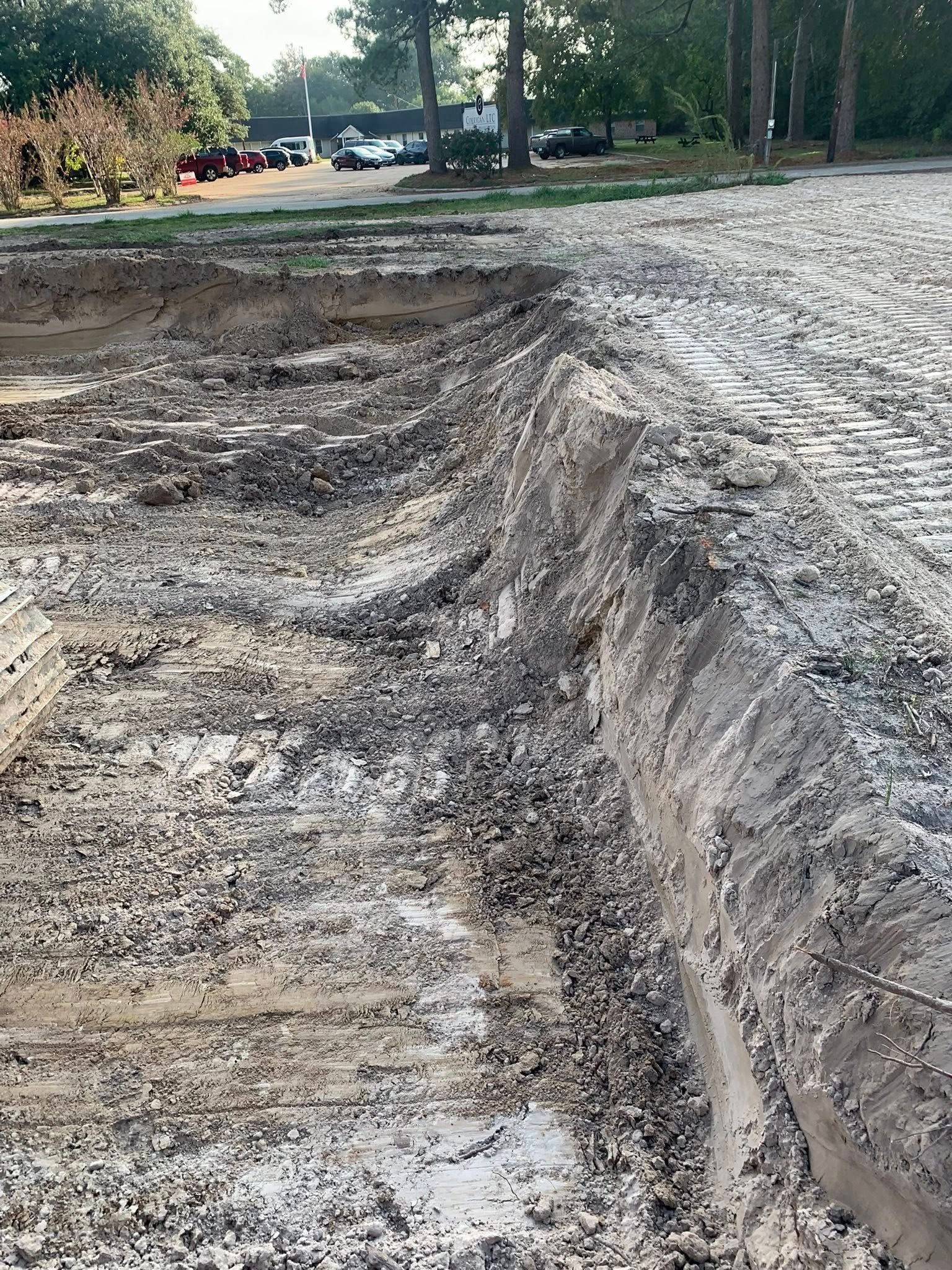 A muddy area with a lot of dirt and trees in the background.