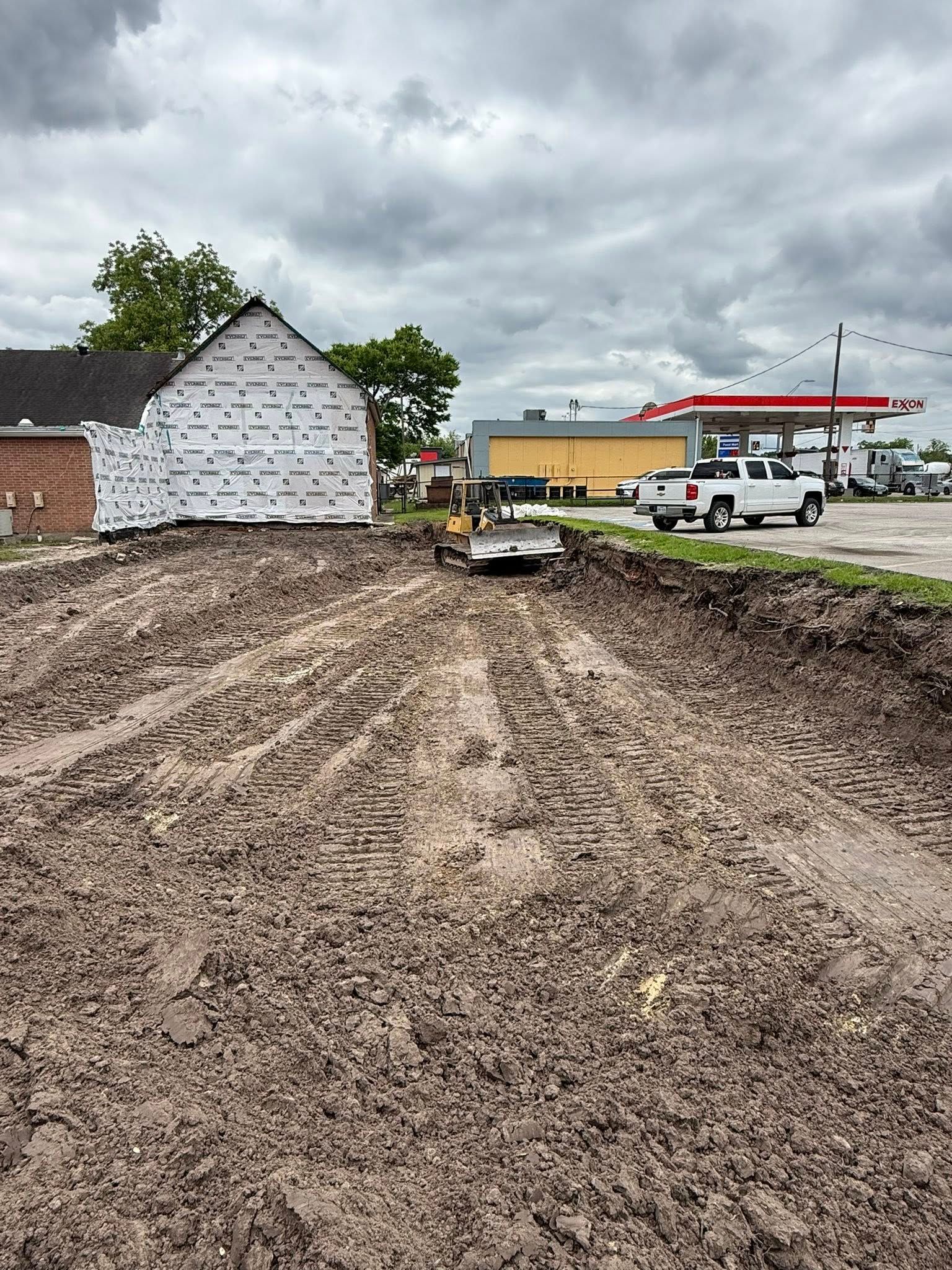 A construction site with a gas station in the background.