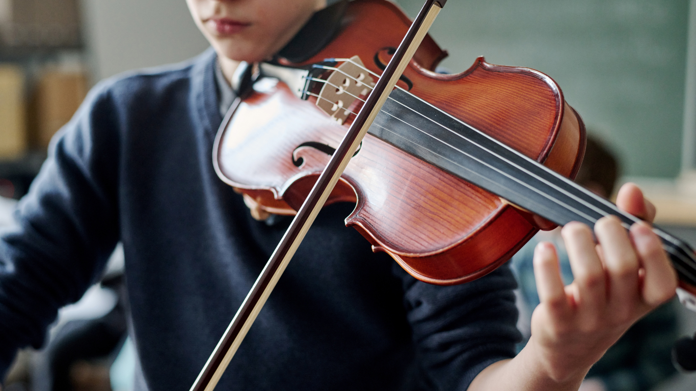 A man is playing a violin with a bow.