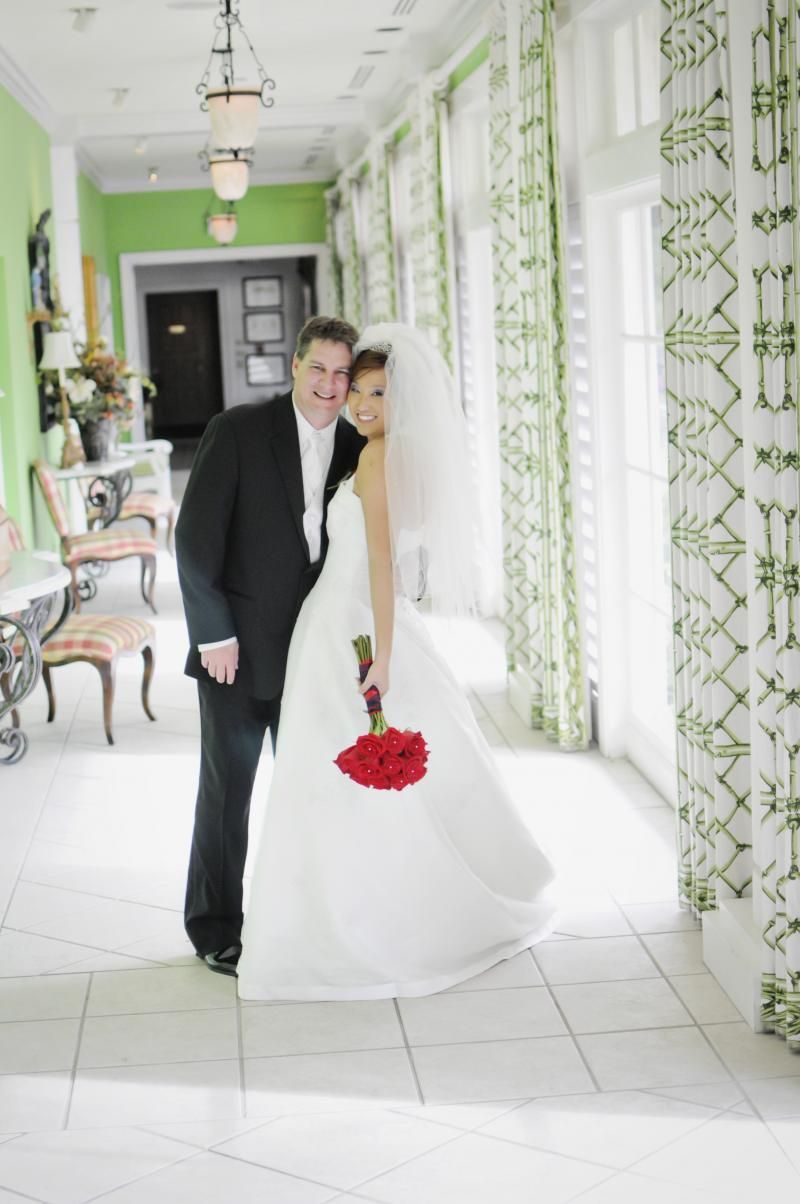 A bride and groom pose for a picture in a hallway