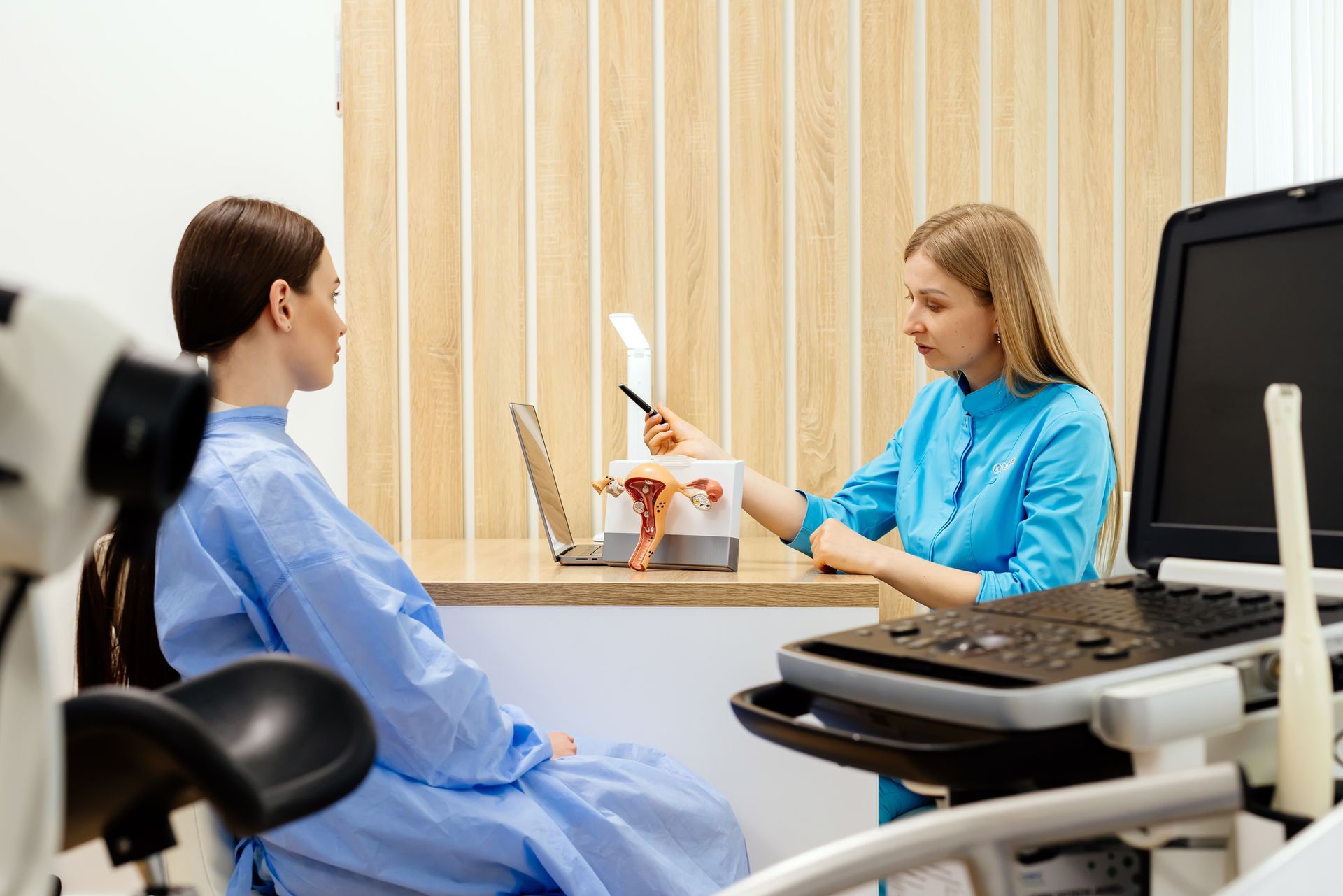 A gynecologist and patient sit in the doctor’s office to discuss PCOS treatment after the exam.