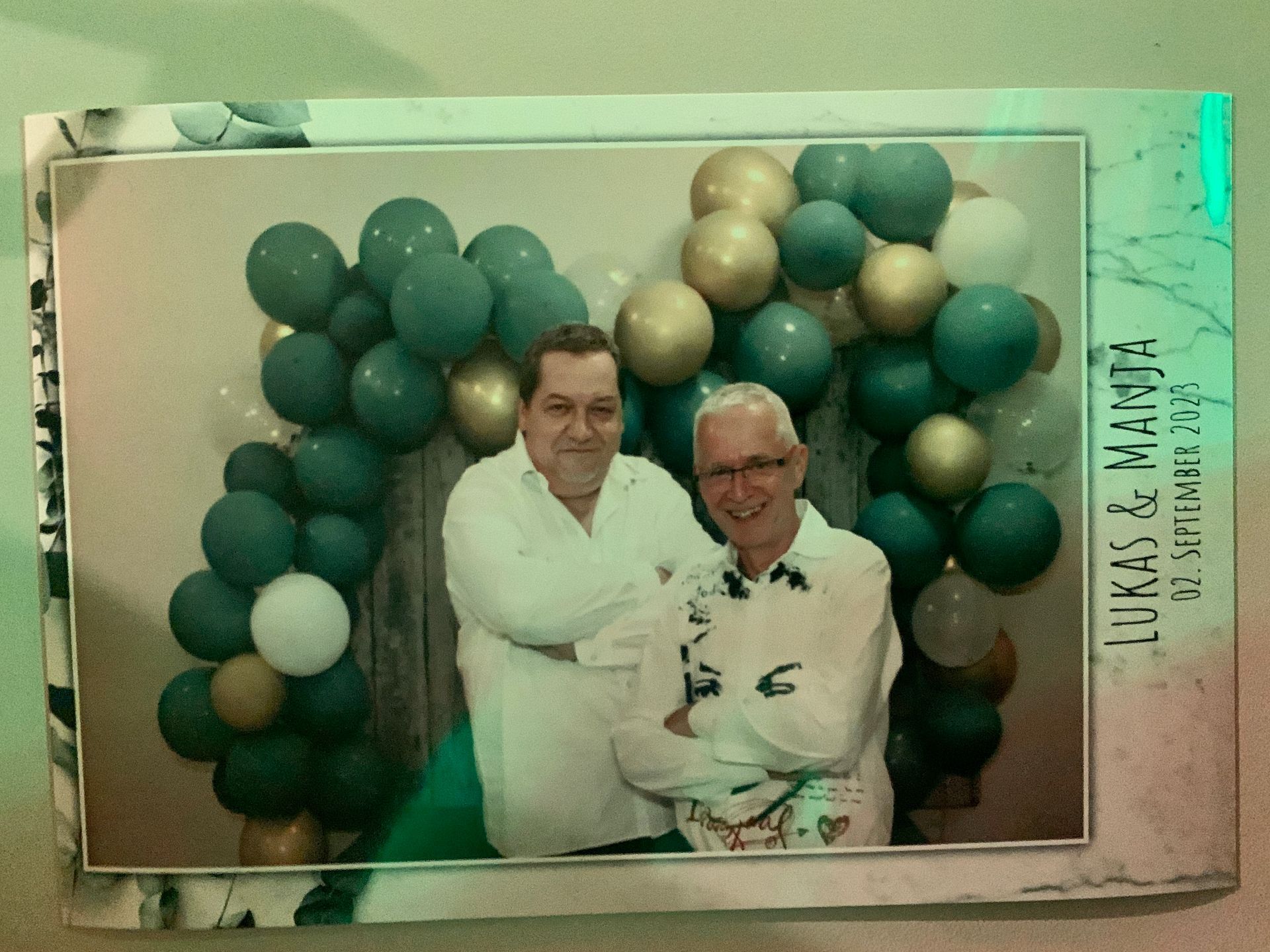 Zwei Männer posieren für ein Foto mit Luftballons im Hintergrund