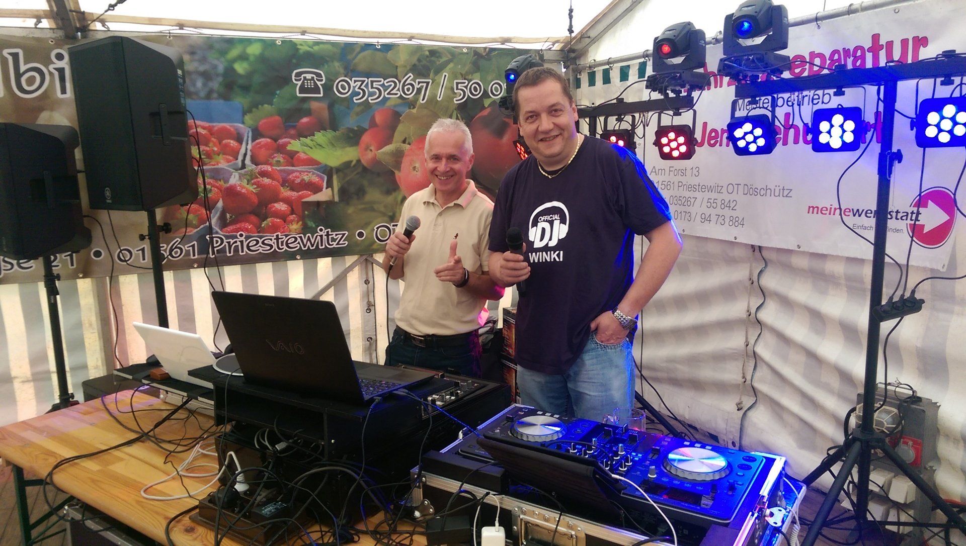 Zwei Männer stehen vor einem DJ-Set.