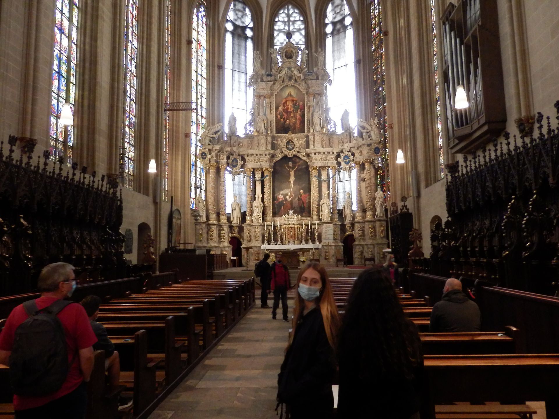 Eine Gruppe maskierter Menschen geht durch eine Kirche.