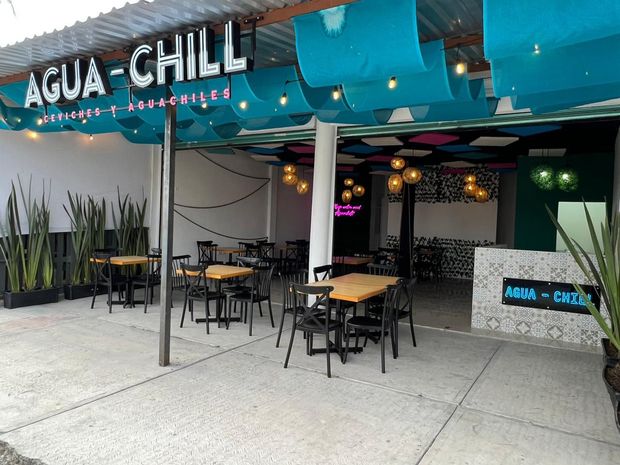 Un restaurante con mesas y sillas y un cartel que dice agua chill