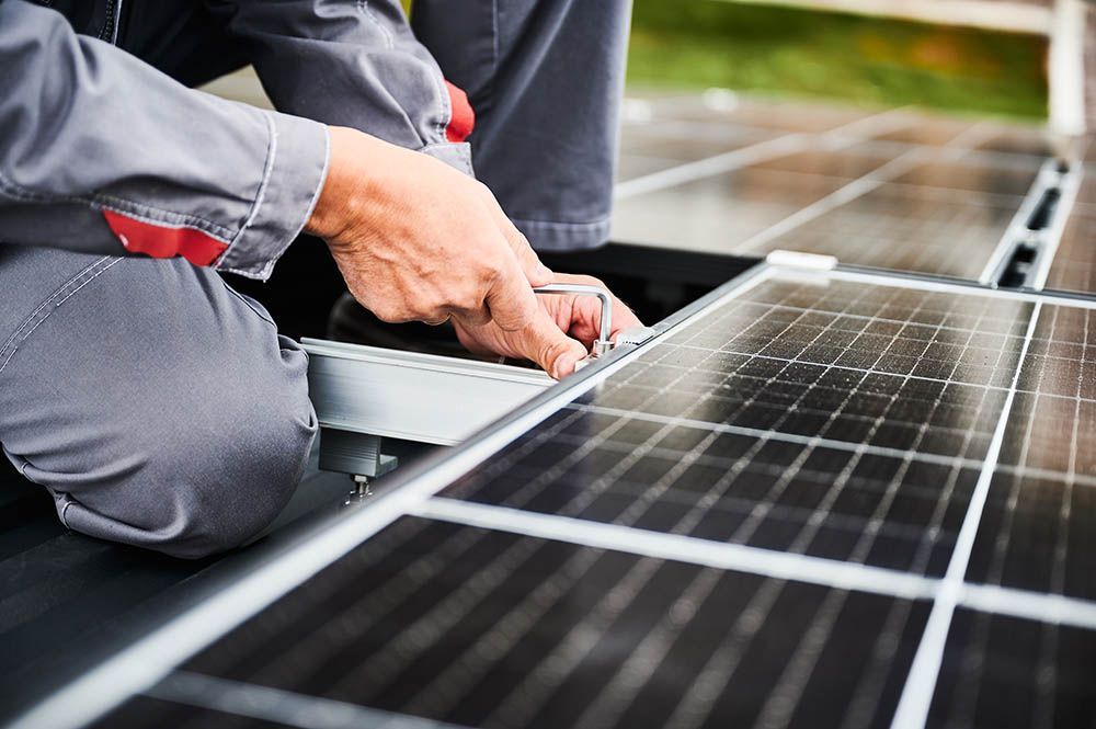 A man is installing solar panels on a roof.