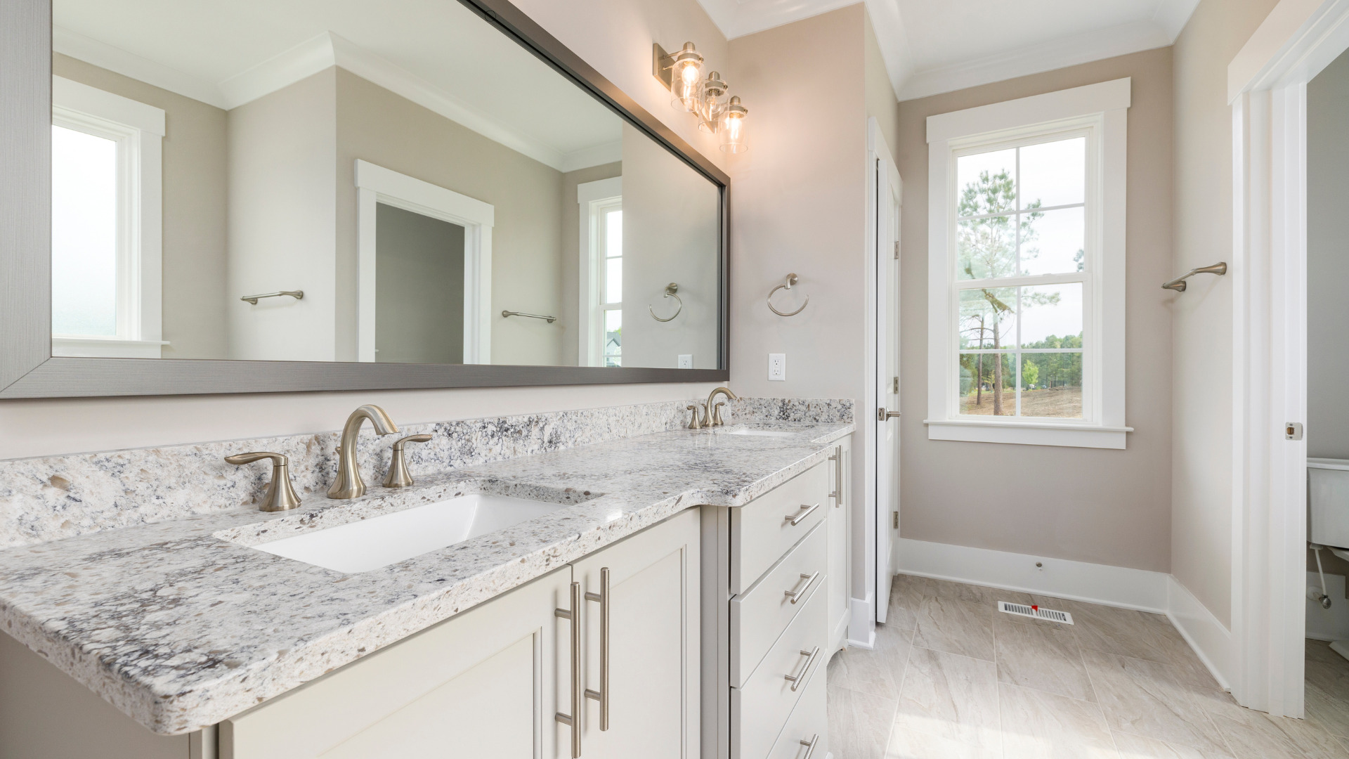 A bathroom with two sinks and a large mirror.