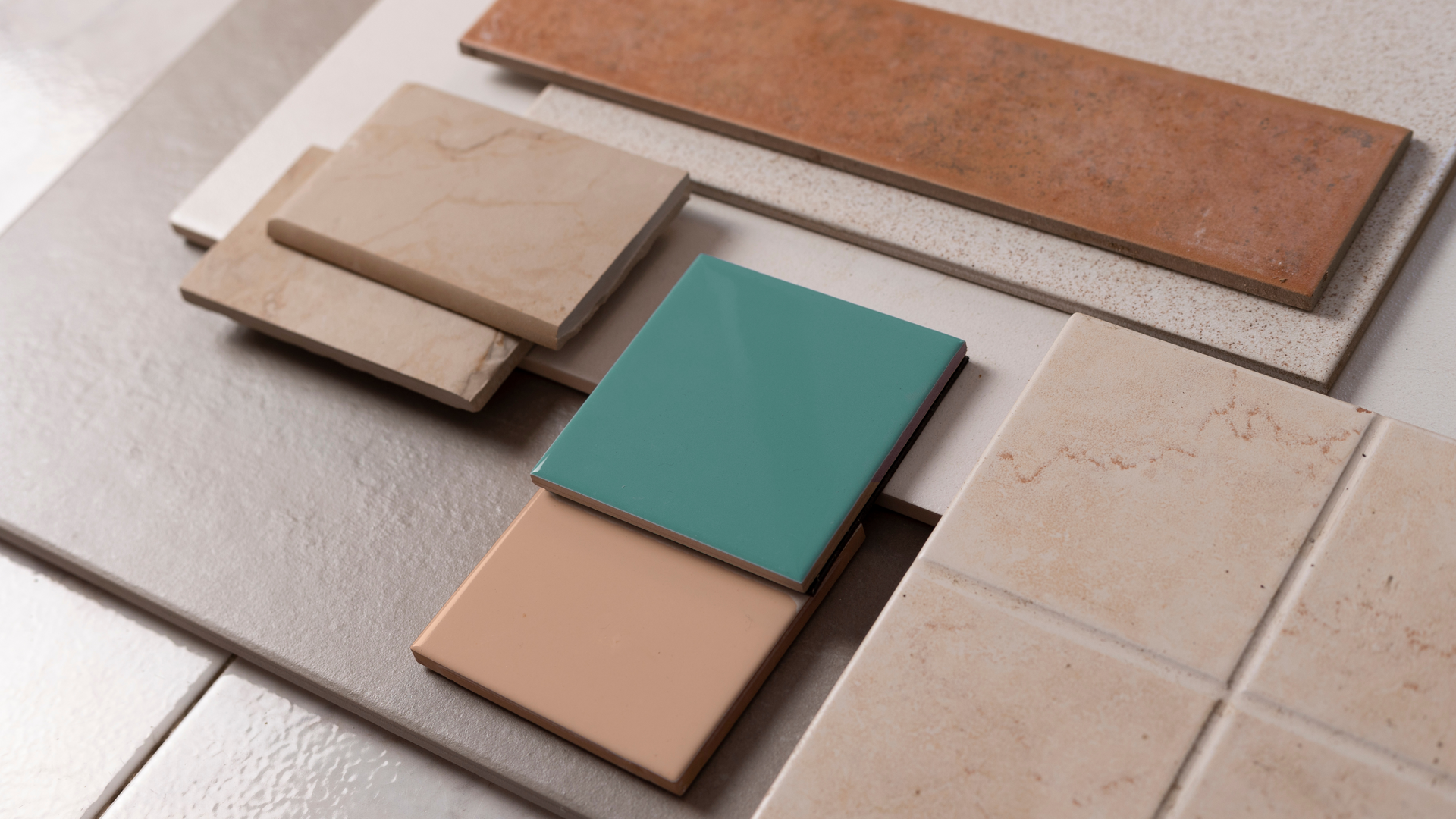 A variety of tiles are stacked on top of each other on a table.
