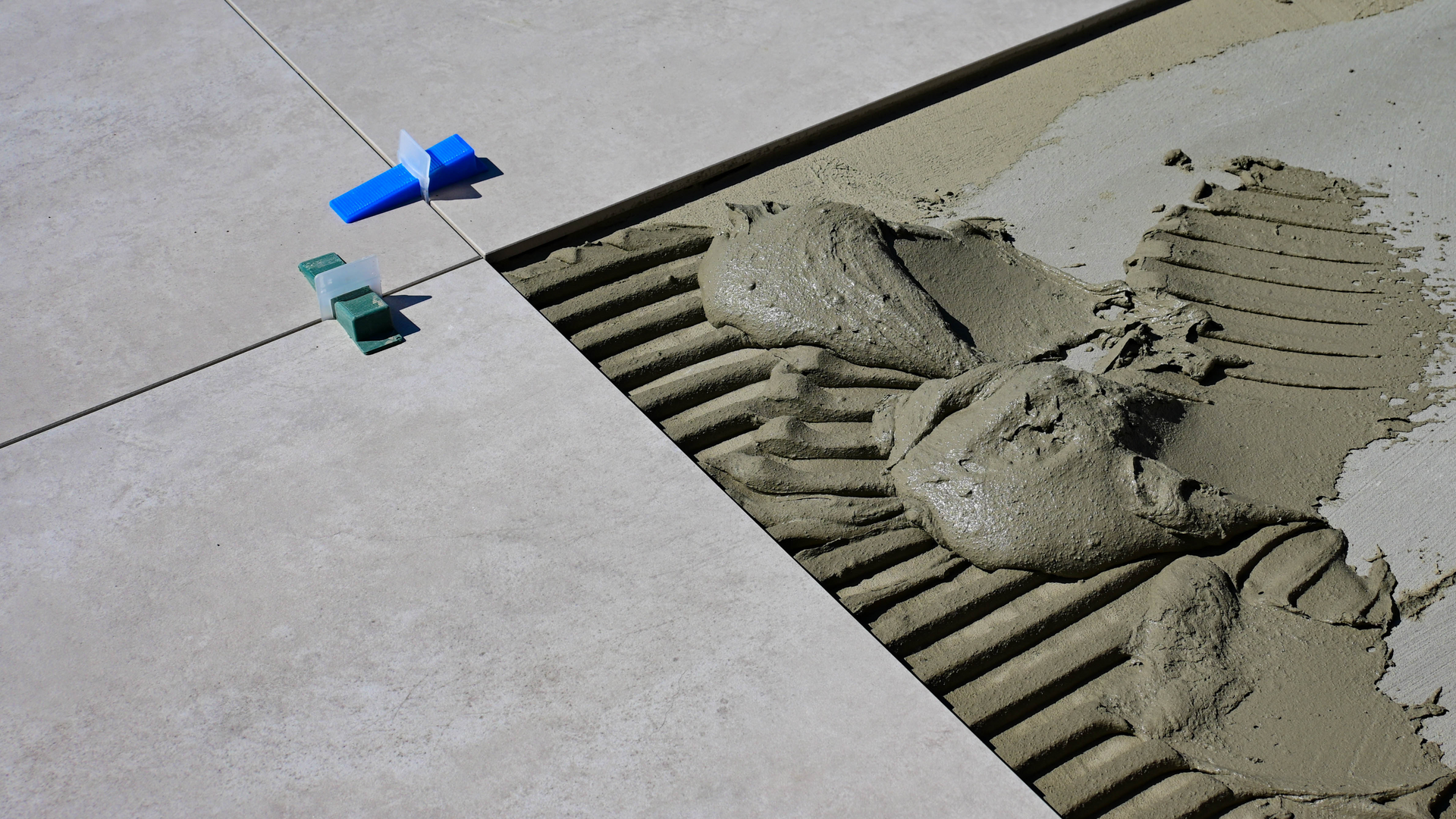 A close up of a tile being installed on a floor