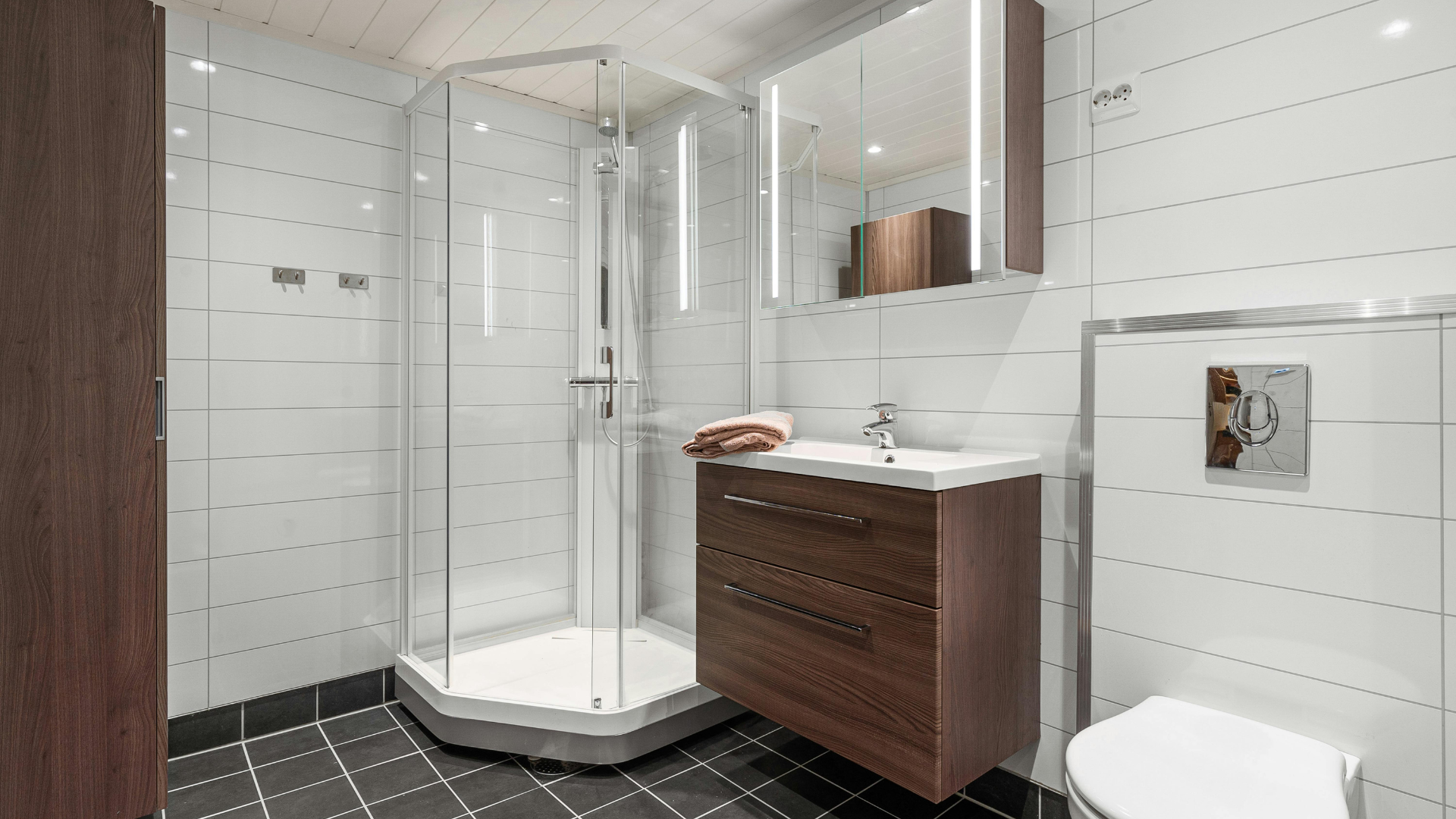 A bathroom with a shower , sink , toilet and mirror.