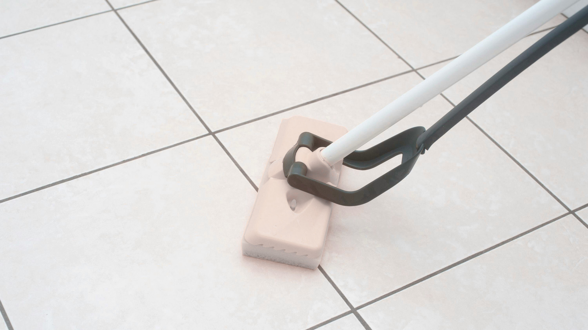 A person is cleaning a tiled floor with a mop