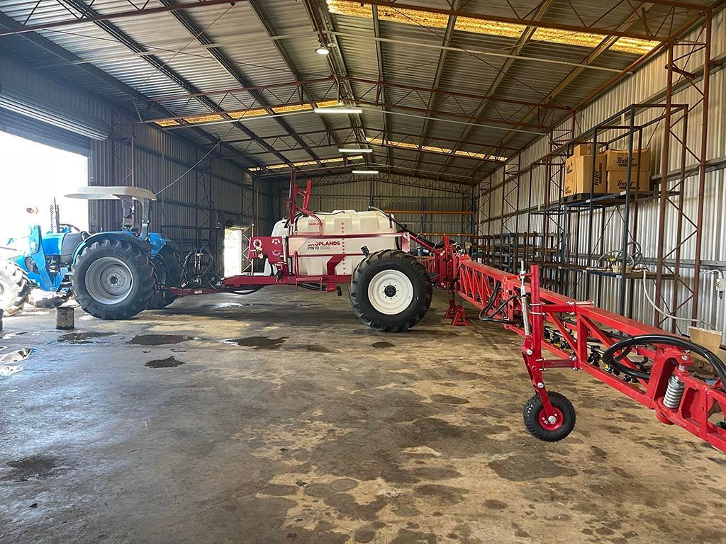 Two tractors are parked in a warehouse next to each other.