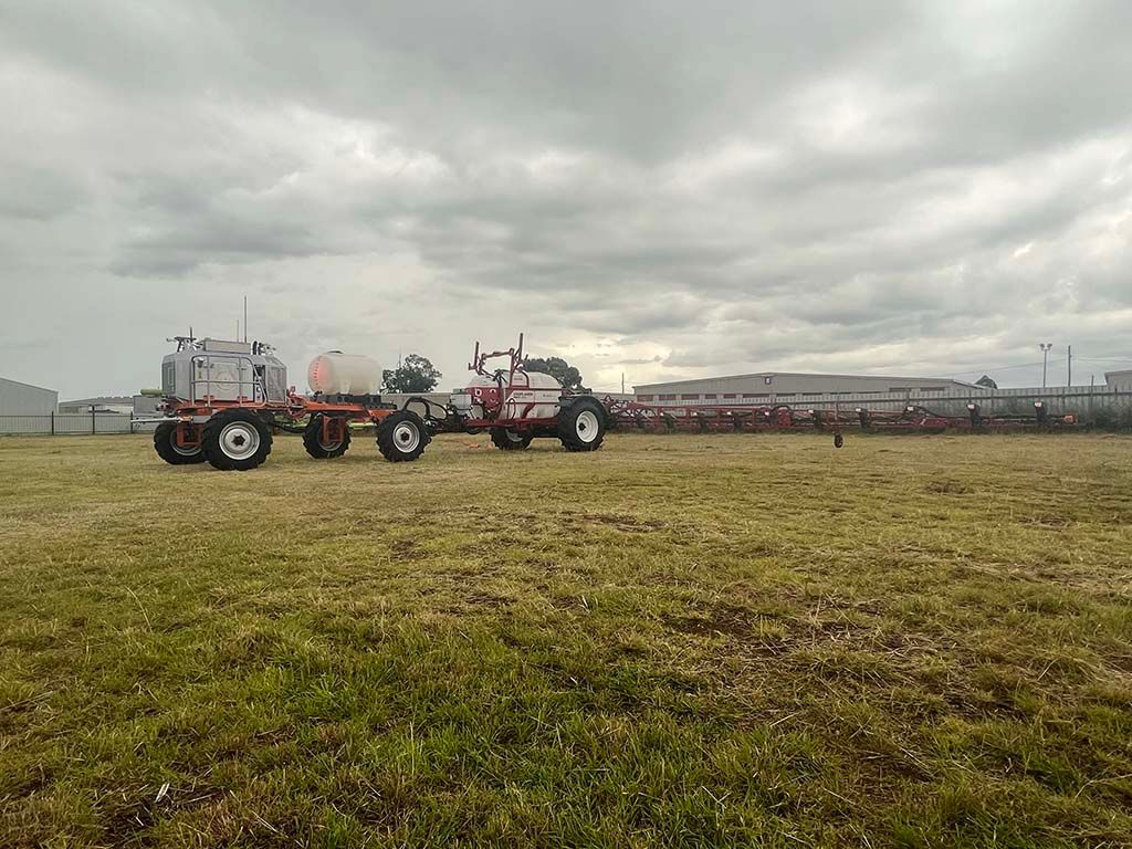 Two tractors are parked in a grassy field.
