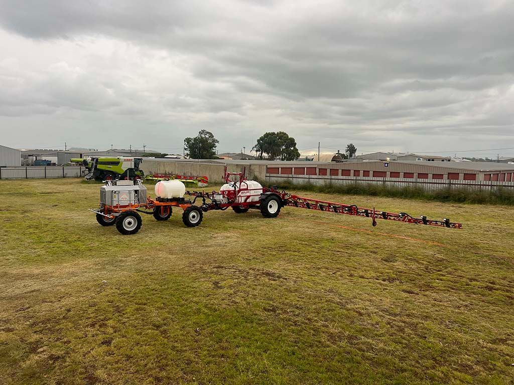 A tractor with a trailer attached to it is spraying a field.