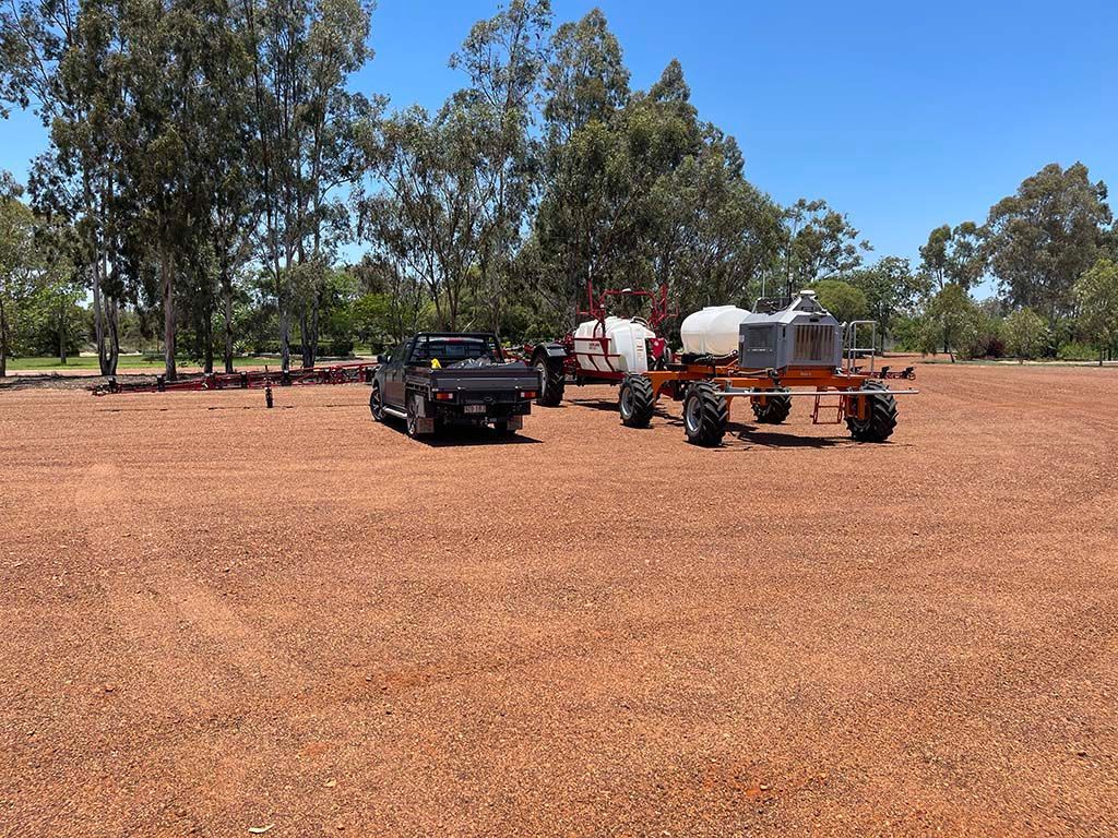 A truck is parked next to a tractor in a field.