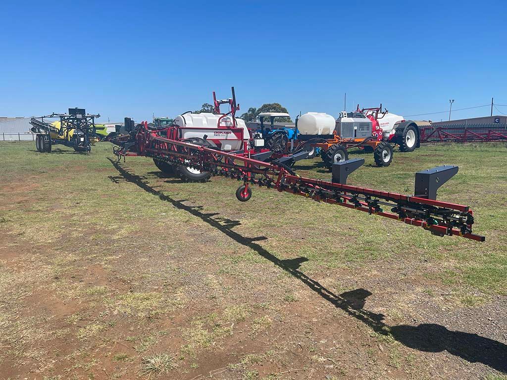 A row of tractors are parked in a grassy field.