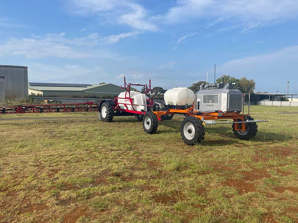 Three tractors are parked in a grassy field.