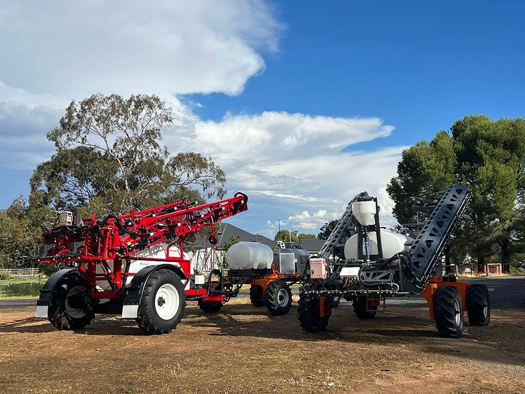Two tractors are parked next to each other in a field.