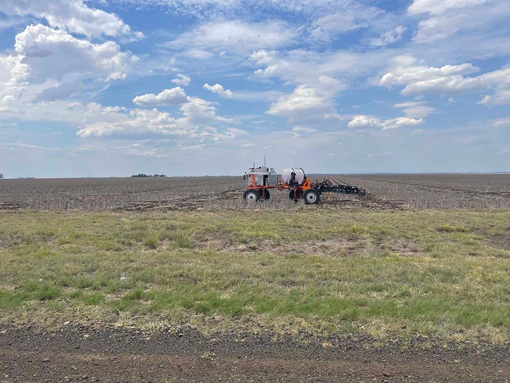 A group of people are working on a tractor in a field.