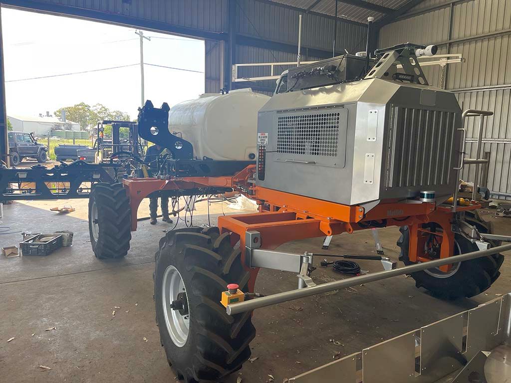 A large orange and white tractor is sitting in a garage.