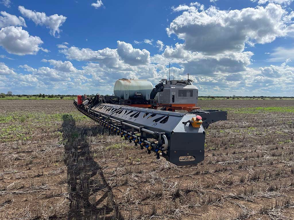 A large machine is sitting in the middle of a field.