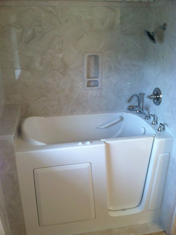 A walk in tub with a door in a bathroom.
