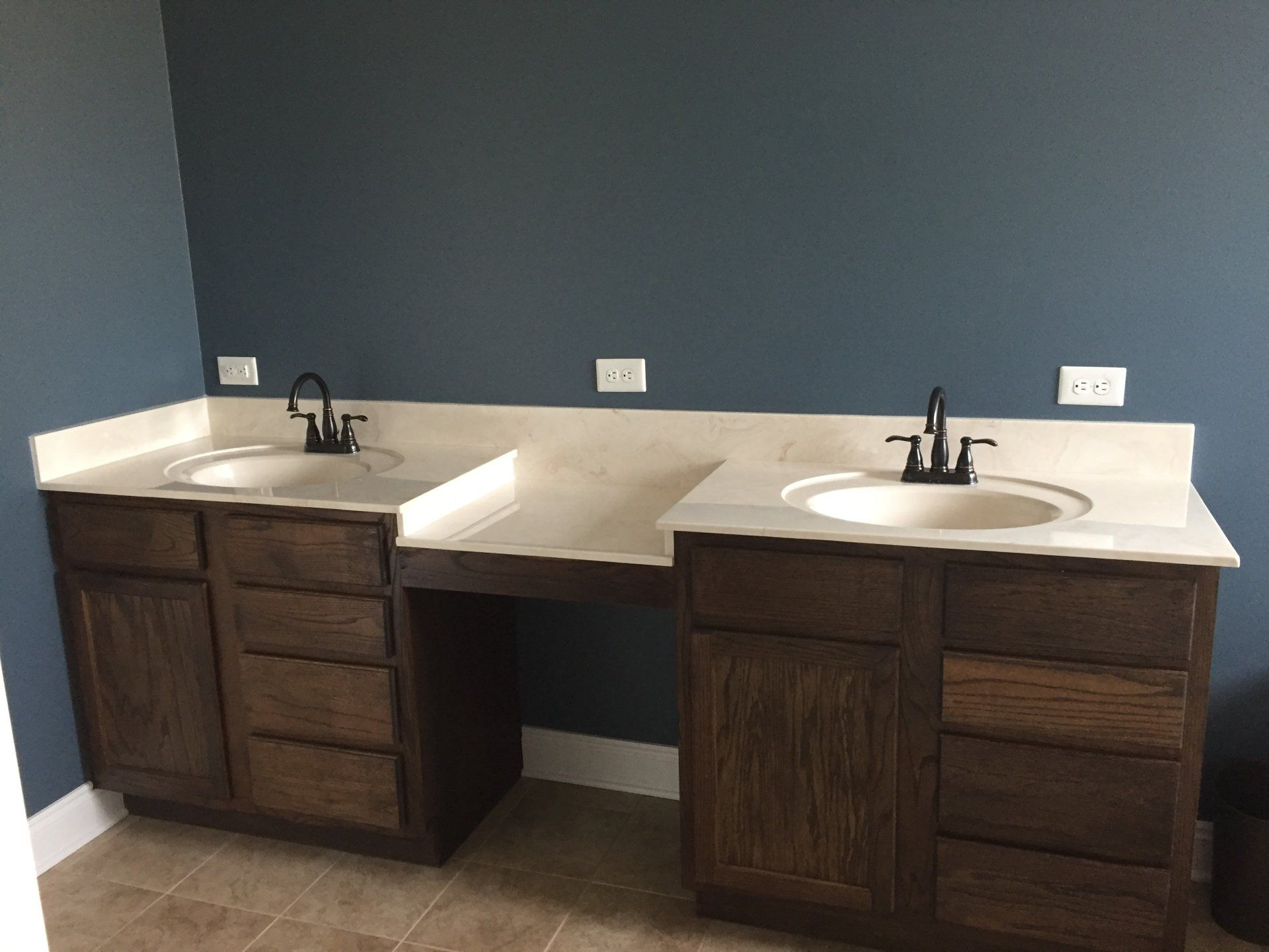 A bathroom with two sinks and a blue wall