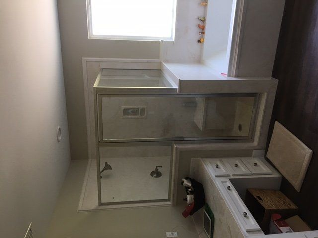 A bathroom with a tub , shower , sink and window.