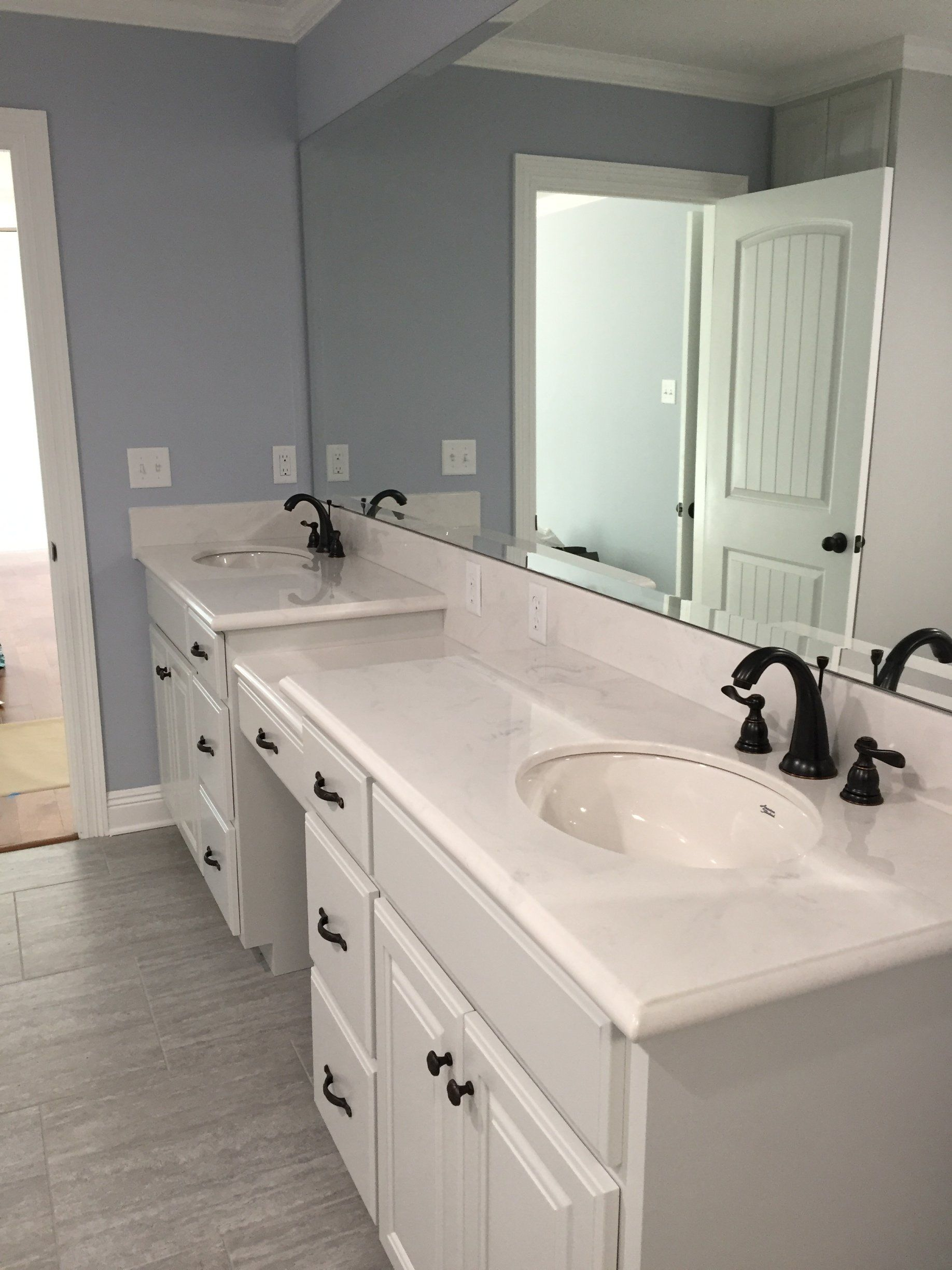 A bathroom with two sinks and a large mirror.