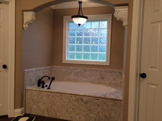 A bathroom with a tub and a window.