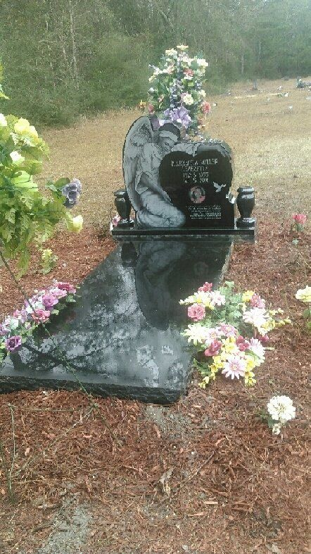 A grave with flowers on it in a cemetery.