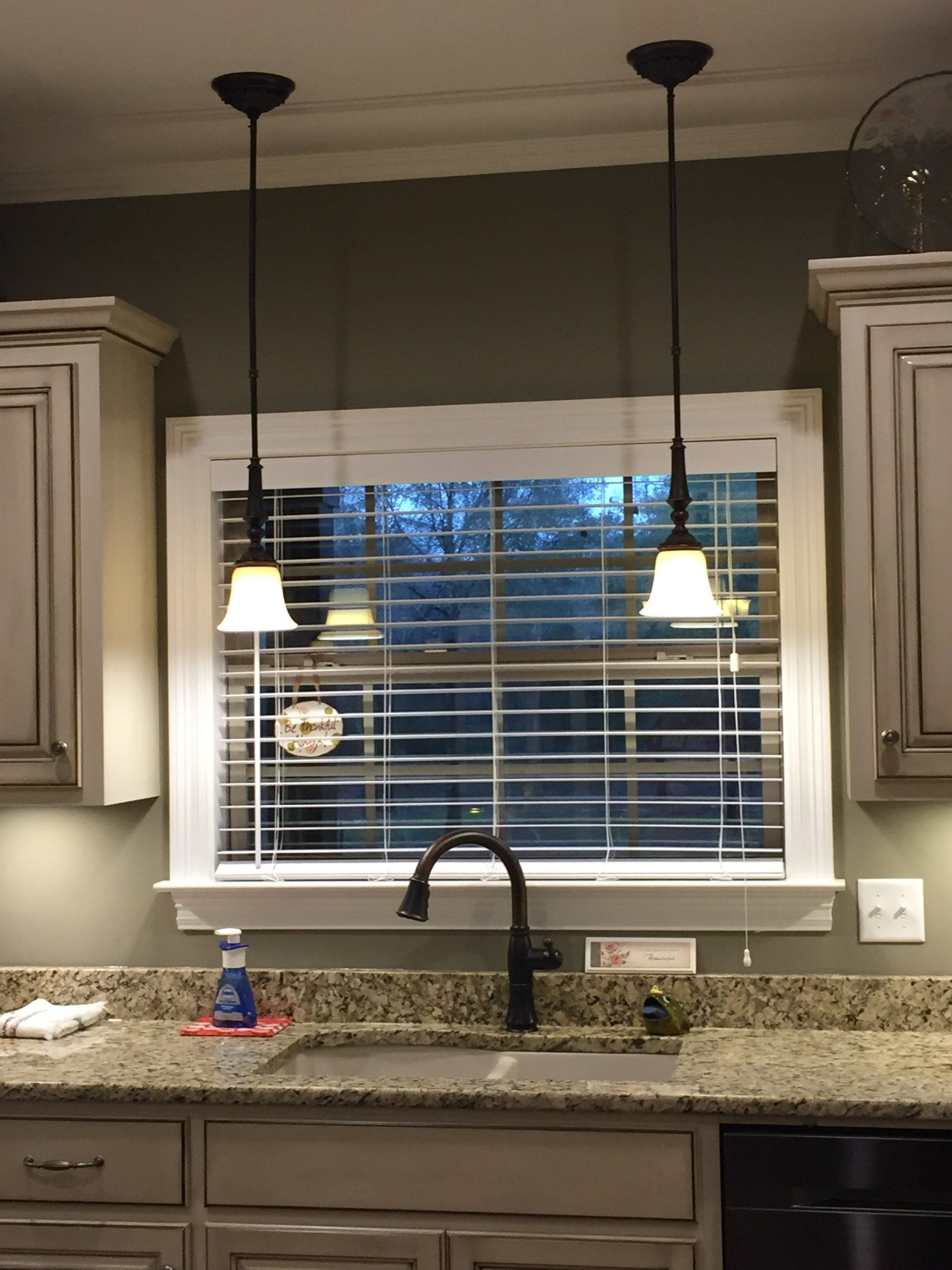 A kitchen with a sink and a window with blinds