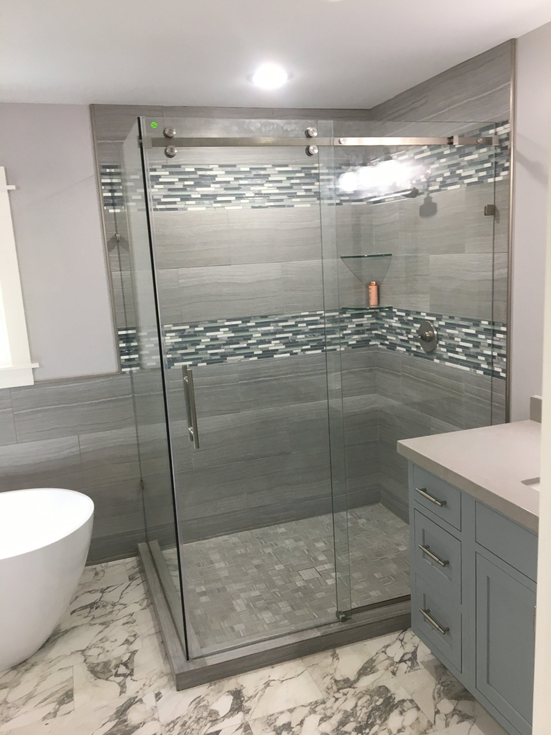 A bathroom with a walk in shower and a bathtub.