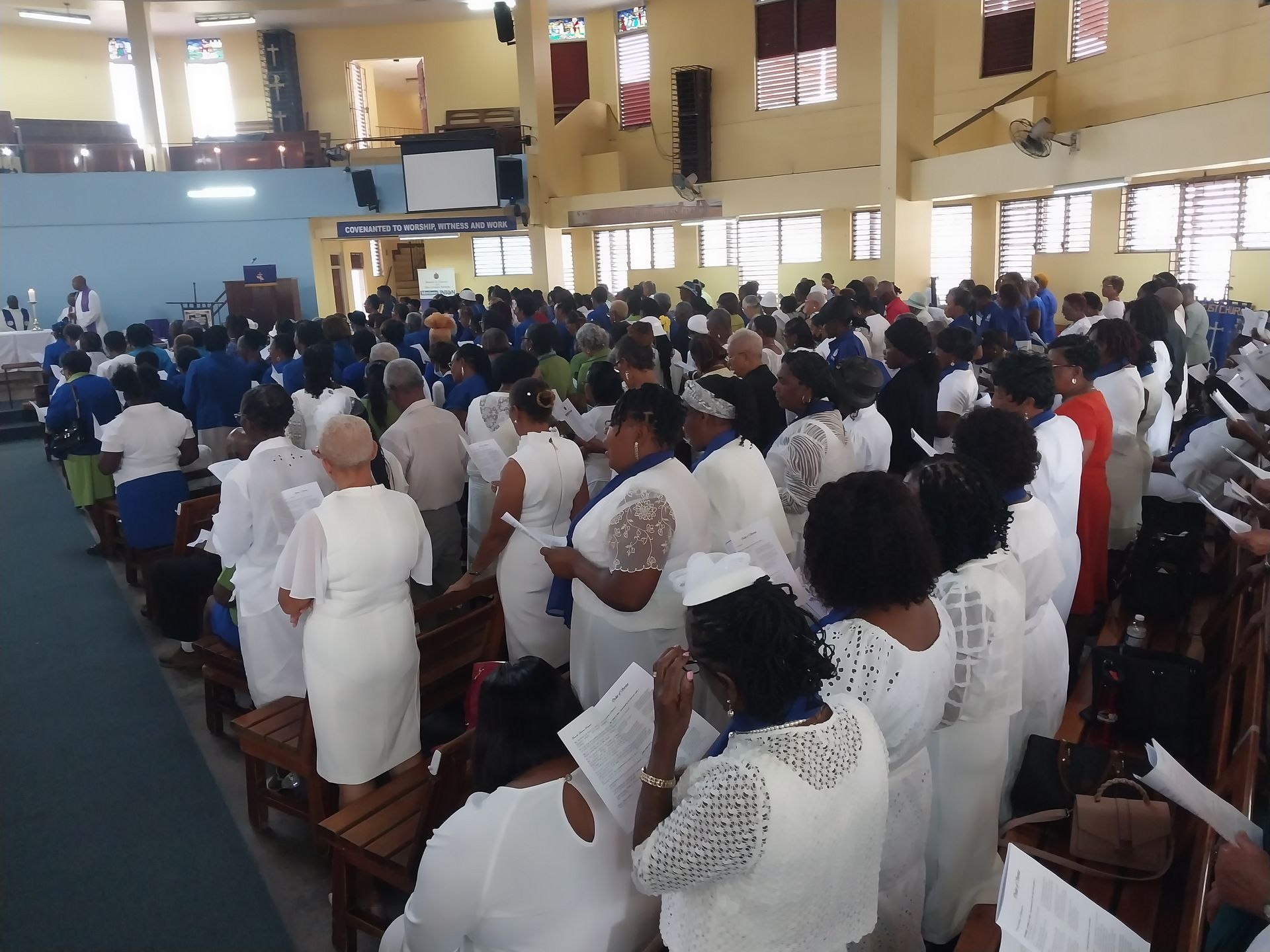 A large group of people in white standing in a church