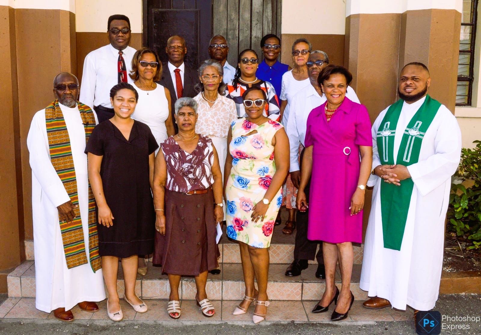A group of people posing for a picture in front of a building