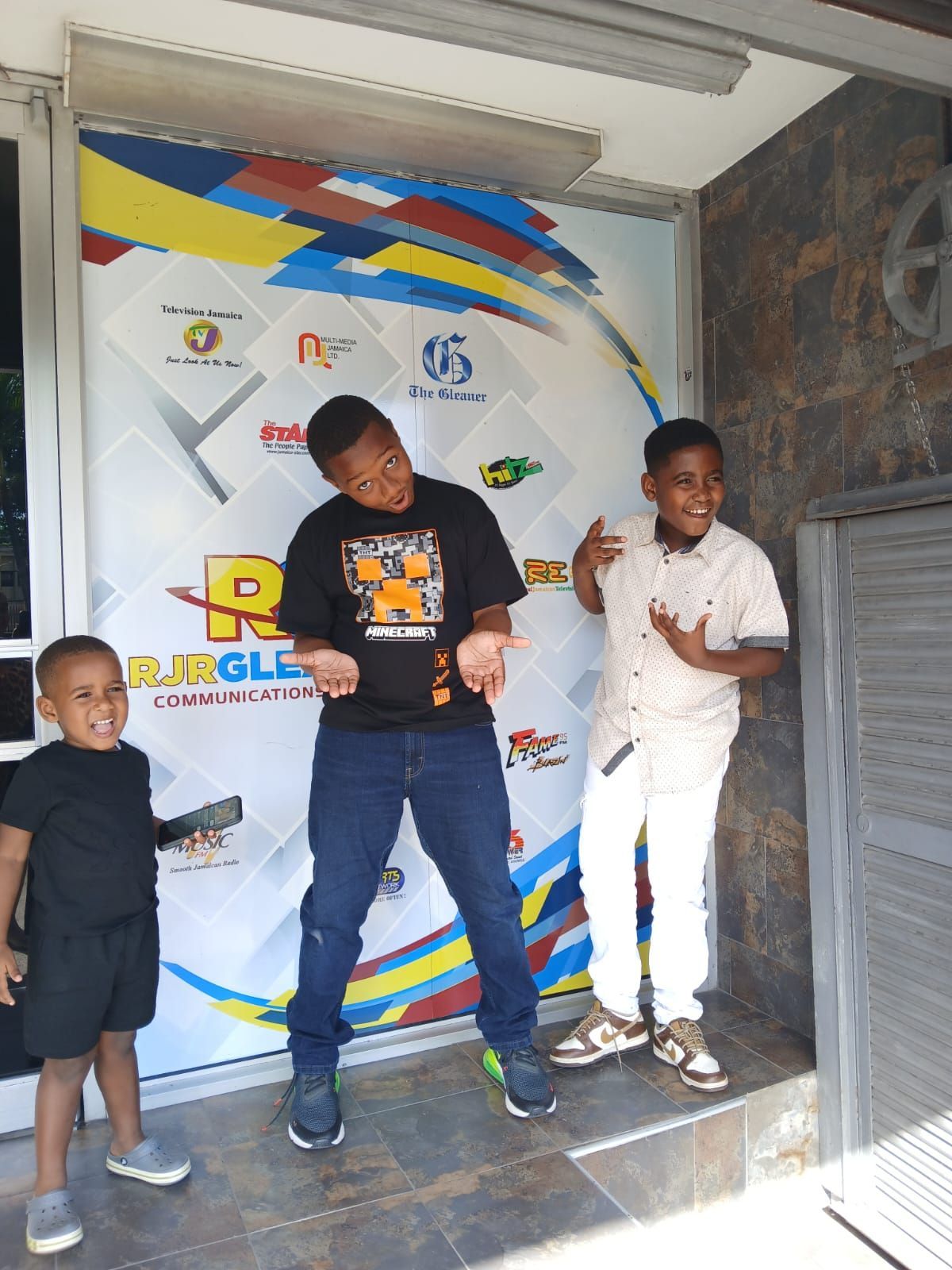 Three young boys standing in front of a sign that says jungle