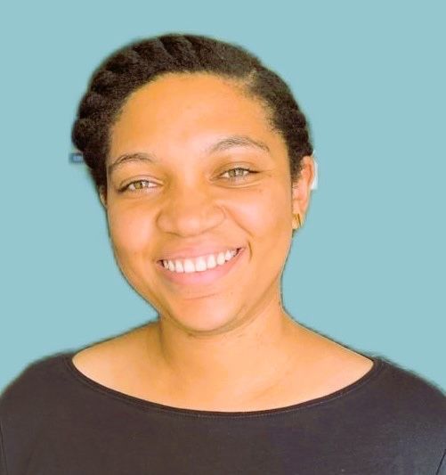 A woman is smiling and wearing a black shirt against a blue background.