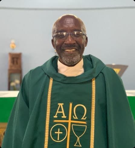 A man wearing a green vest with the letters aio on it
