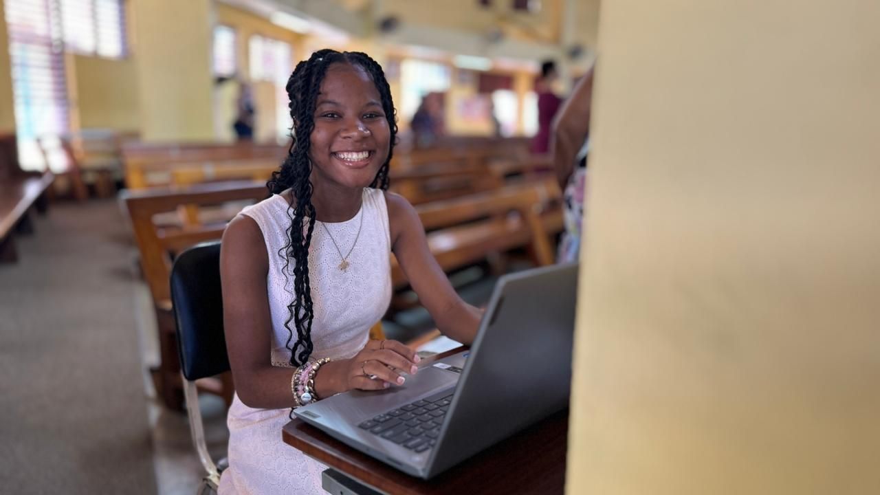 A woman is sitting at a desk with a laptop computer.