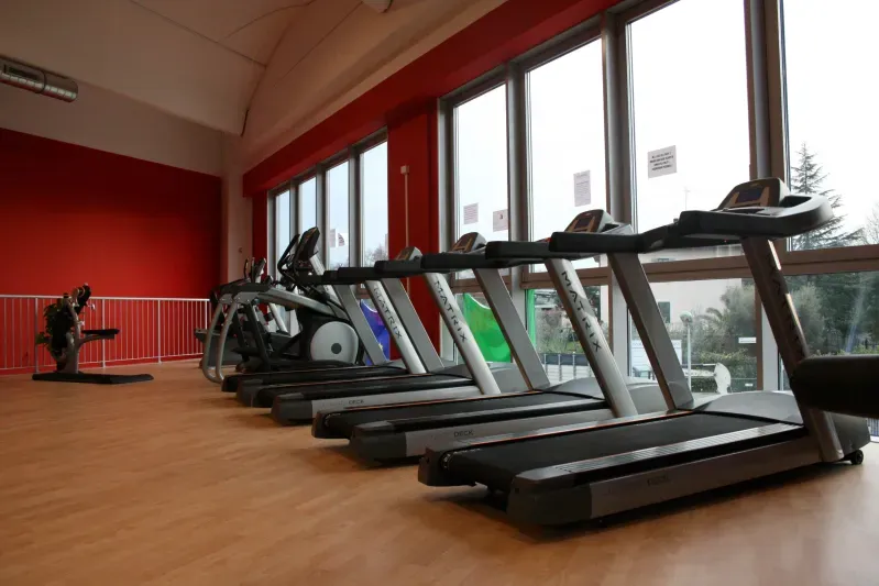 Una fila di tapis roulant sono allineati in una palestra.